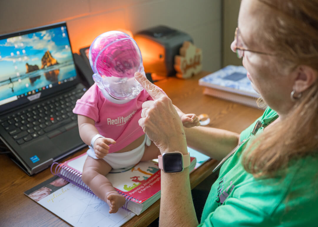 Woman doing demonstration on an infant doll at the health department
